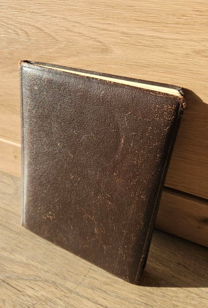 Ein Foto von einem kleinen dunkelbraunen unscheinbaren Buch